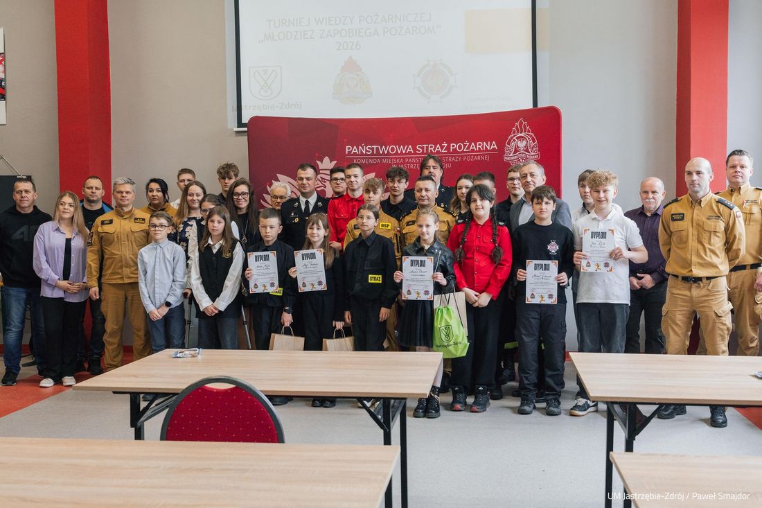 Władze miasta, komendańci straży pozarnej, organizatorzy i uczestnicy konkursu wspólnie pozujący z dyplomami i nagrodami