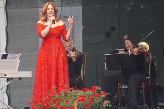 Śpiewaczka podczas występu solo ubrana w elegancką czerwona suknię