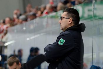 Trener Robert Kalaber obserwuje poczynania drużyny podczas meczu hokejowego.
