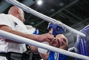 Trener spryskuje zawodnika wodą.