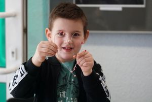 Dzieci wykonujące serce z koralików podczas warsztatów z metaloplstyki