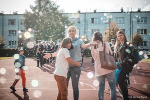 Wychowawczyni z podopieczną w otoczeniu baniek mydlanych.