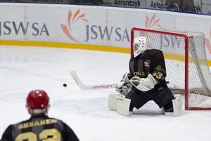 Bramkarz gości paruje krążek.