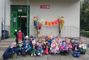 Dzieci przed budynkiem - pozują do zdjęcia.