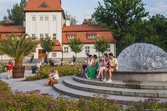 Ludze siedzą na fontannie 
