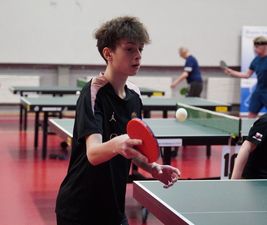 Młody tenisista atakuje czerwona rakietą