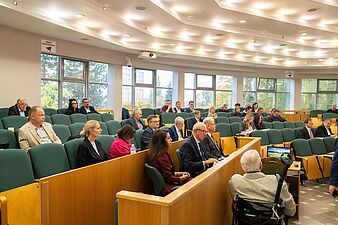 Widok na salę sesyjną, gdzie siedzą radni i naczelnicy wydziałów