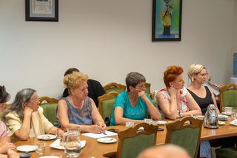 pięć kobiet siedzi przy stole konferencyjnym