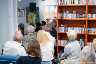 Uczestnicy siedzą na zewnetrznej sali 