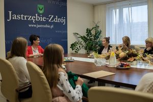 Spotkanie - uczestnicy siedzą przy stole i rozmawiają.