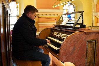 Organmistrz prezentujący dźwięki organów 