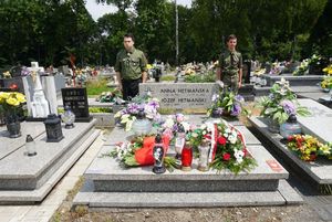 Grób powstańca udekorowany kwiatami i plakietką