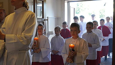 Ministranci wchodzacy do kościoła podczas procesji.
