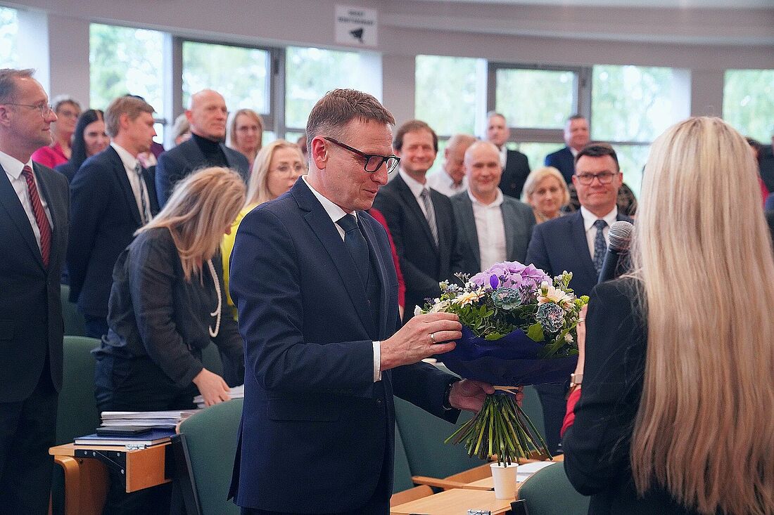 Prezydent odbierający kwiaty na sesji rady miasta