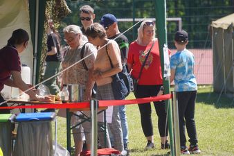 Mieszkańcy przy stanowisku z kiełbaskami