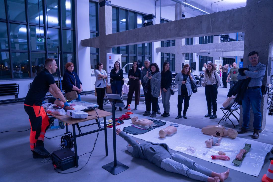 osoby obserwują pokaz pierwszej pomocy