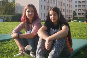 Dwie nastolatki siedzące na trawie podczas pikniku kocykowego