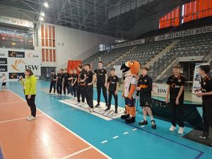 prowadząca rozpoczyna wydarzenie za jej placeami maskotka Jastrząb oraz sędziowie w czarnych strojach