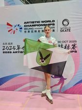 Zawodniczka pozująca na tle ścianki z flagą 