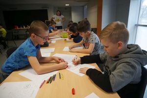 Grupka dzieci rysuje 