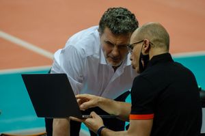 Trener i analityk spoglądają w ekran laptopa.