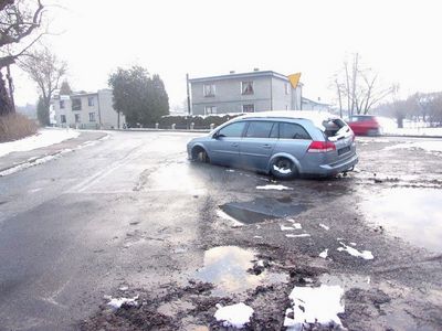 Srebrny wrak samochodu stojący na ulicy