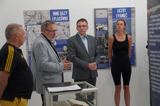 Uczestnicy otwarcia wystawy wsłuchujący się w wykład dyrektora placówki