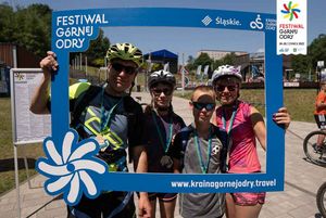 Uczestnicy rajdu rowerowego na OWN odbierają medale i robią pamiątkowe zdjęcia.