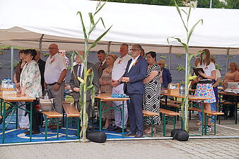 Ludzie stoją pod namiotem podczas dożynek ujęcie z boku