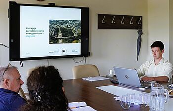 Przedstawiciel pracowni architektonicznej Medusa Group pracuje na laptopie, na ekranie wyświetla się prezentacja