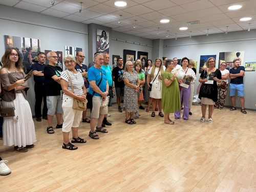 Ujęcie szerokie dużo ludzi słuchających prelekcji artysty