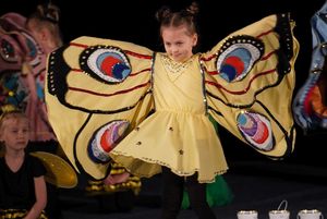 dziewczynka przebrana za motyla występuje na scenie