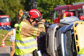 Sędzia techniczny przeciera oczy . Obok niego przewrócone samochody