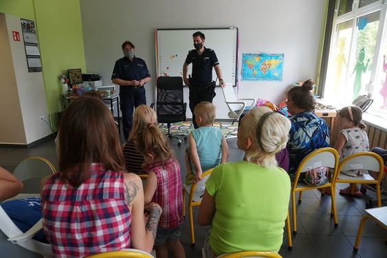 Widok na pełną salę z dziećmi, opiekunami i policjantami