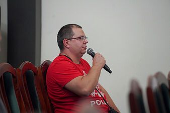 Jeden z uczestników spotkania zadaje pytanie do mikrofonu