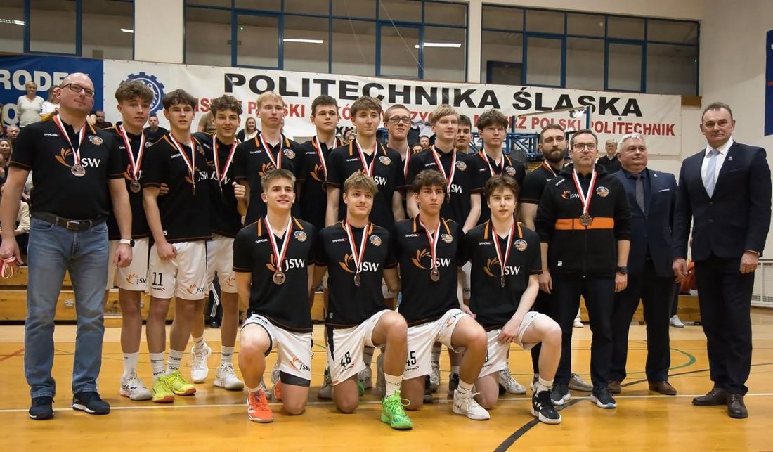 Grupowe zdjęcie drużyny i trenerów z medalami