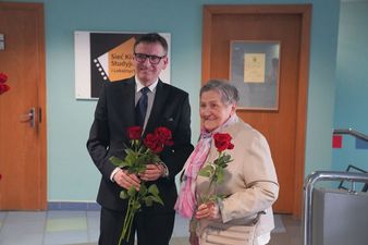 Prezydent wręcza róże pani w holu kina centrum z okazji dnia kobiet