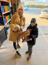 Kobieta trzymająca karmik, obok chłopiec trzymający karmę