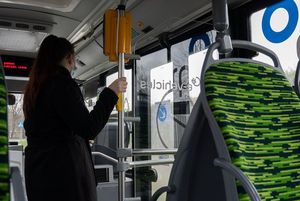 Widok na wnętrze autobusu z pasażerami.