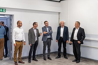 męzczyxni w garniturach odbierają obiekt