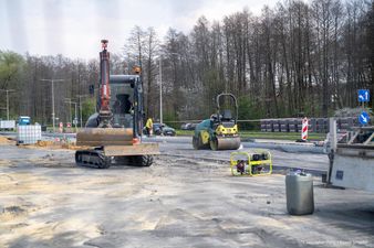 mała koparka i walec drogowy na placu robót