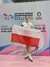 Zawodniczka pozująca na tle ścianki z flagą Polski