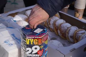 Dłoń wrzuca pieniądze do puszki