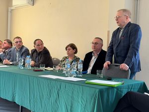 przy nakrytym zielonym płótnie stole prezydialnym siedzi Damian Gałuszka, Michał Urgoł, Piotr Szereda, Bogusława Augustyn oraz przedstawiciele JZWiK