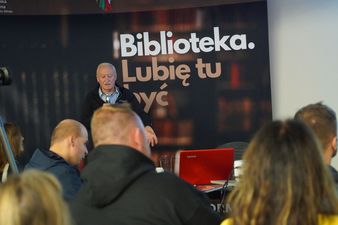 Krzysztof Wielicki przemawiający za nim rollup z napisem Biblioteka. Lubię tu żyć