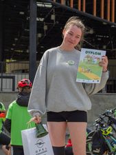 Uśmiechająca się dziewczyna z dyplomem i dzwonkiem w ręku