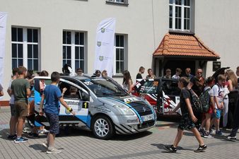 dzieci przyglądające się samochodom sportowym