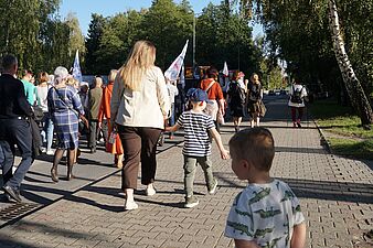 mama widziana od tyłu idzie z dwójką synów