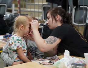 Kobieta malująca twarz dziecka