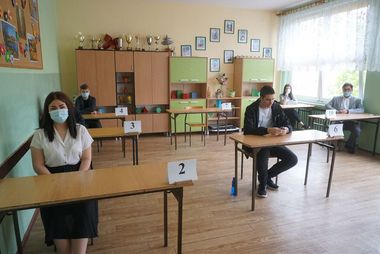 Zdjęcie przedstawia uczniów w ławkach oczekujących na egzamin.